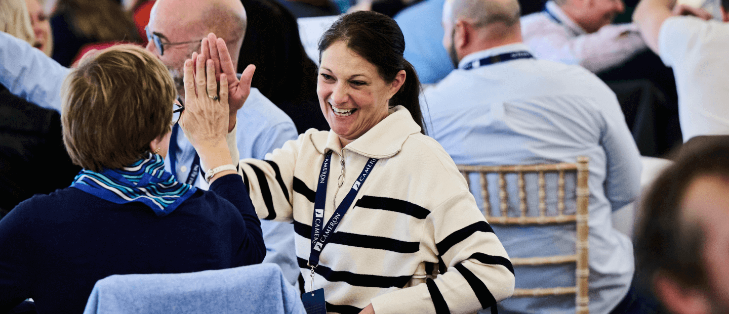 Women high-fiving at a conference 