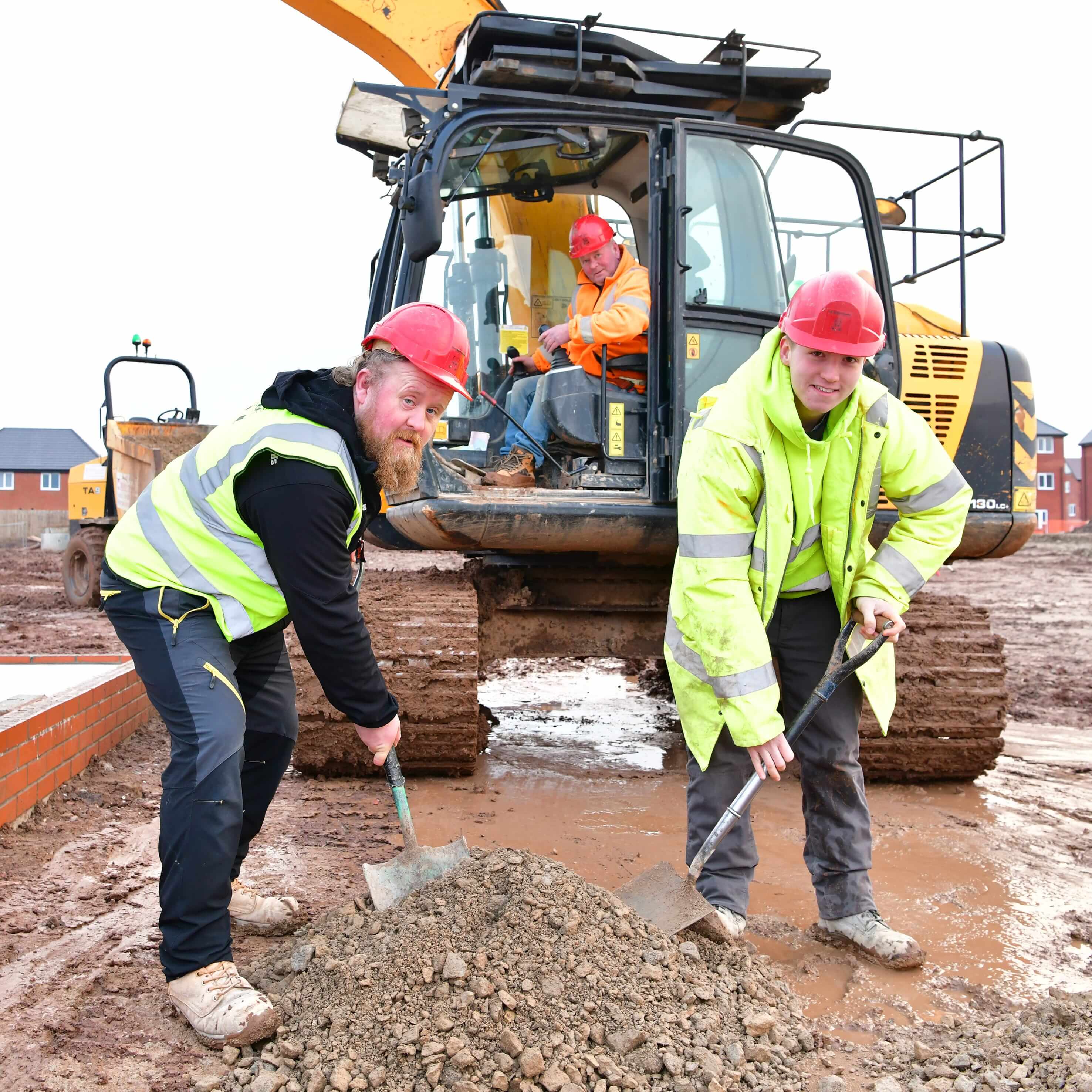 2 groundworkers digging on site in front of an excavator