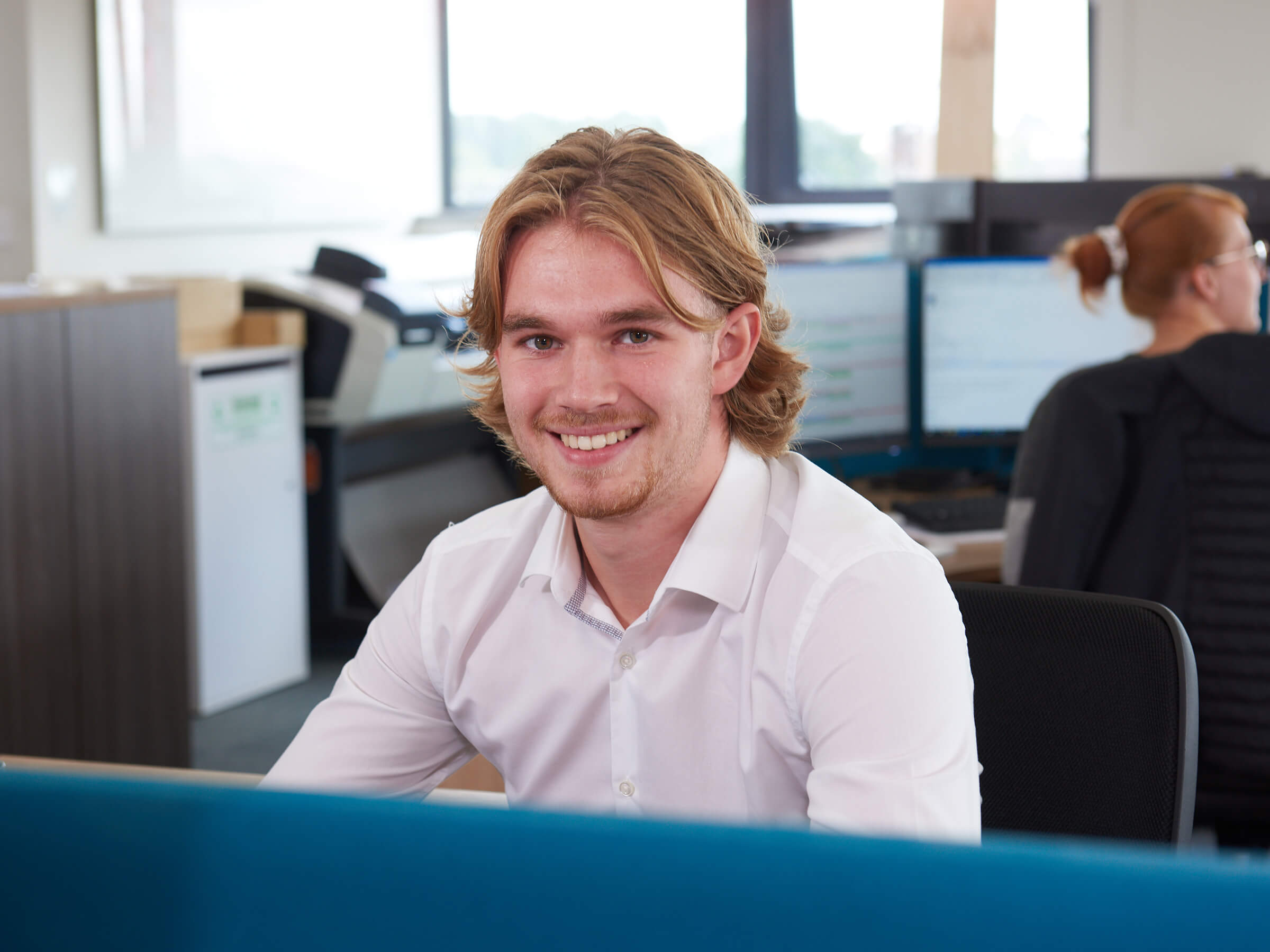 Friendly member of customer care team sitting at desk 