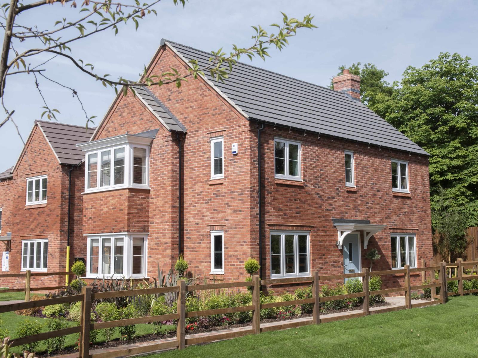 View of new build brick house and lawn 