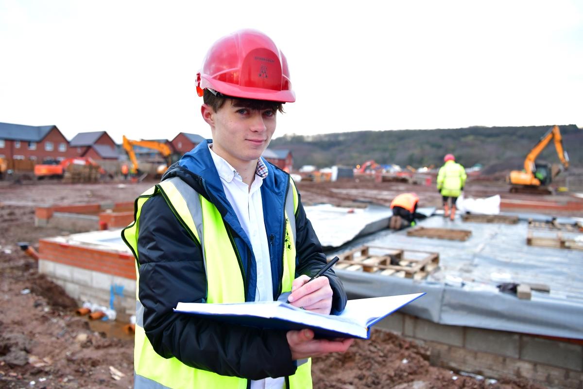 Taryn Grant on development site with hard hat and notebook